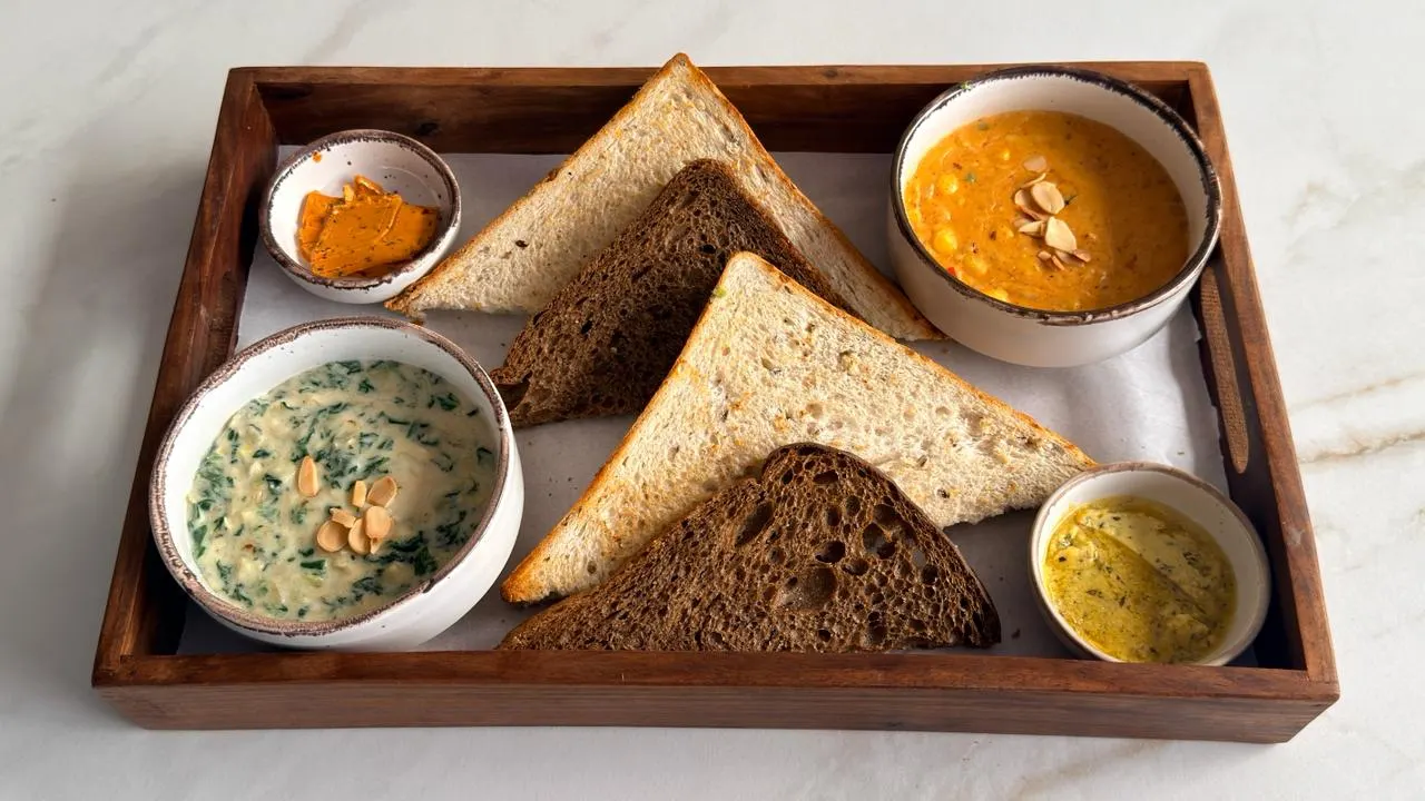 Assorted Bread Basket at Cafe OneTen — fresh breads with four dips
